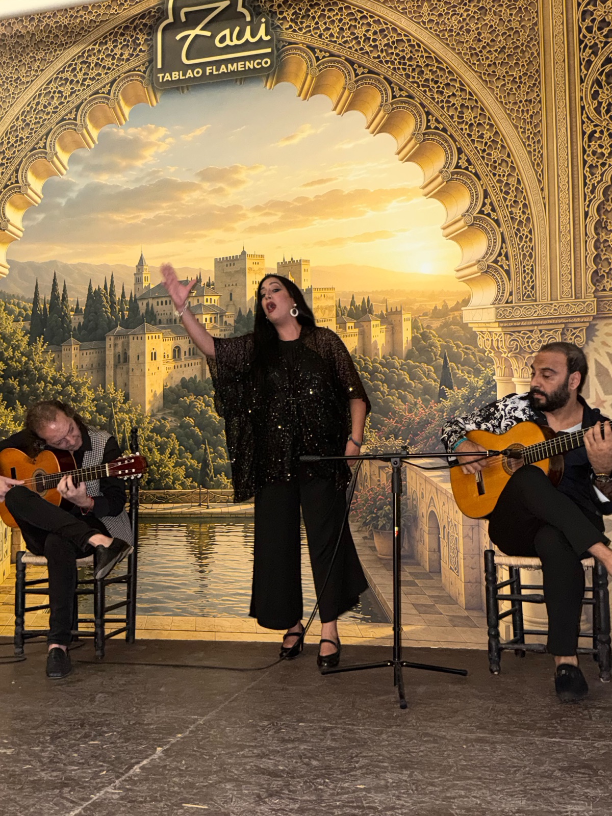 Cantaora acompañada por dos guitarristas en Zawi